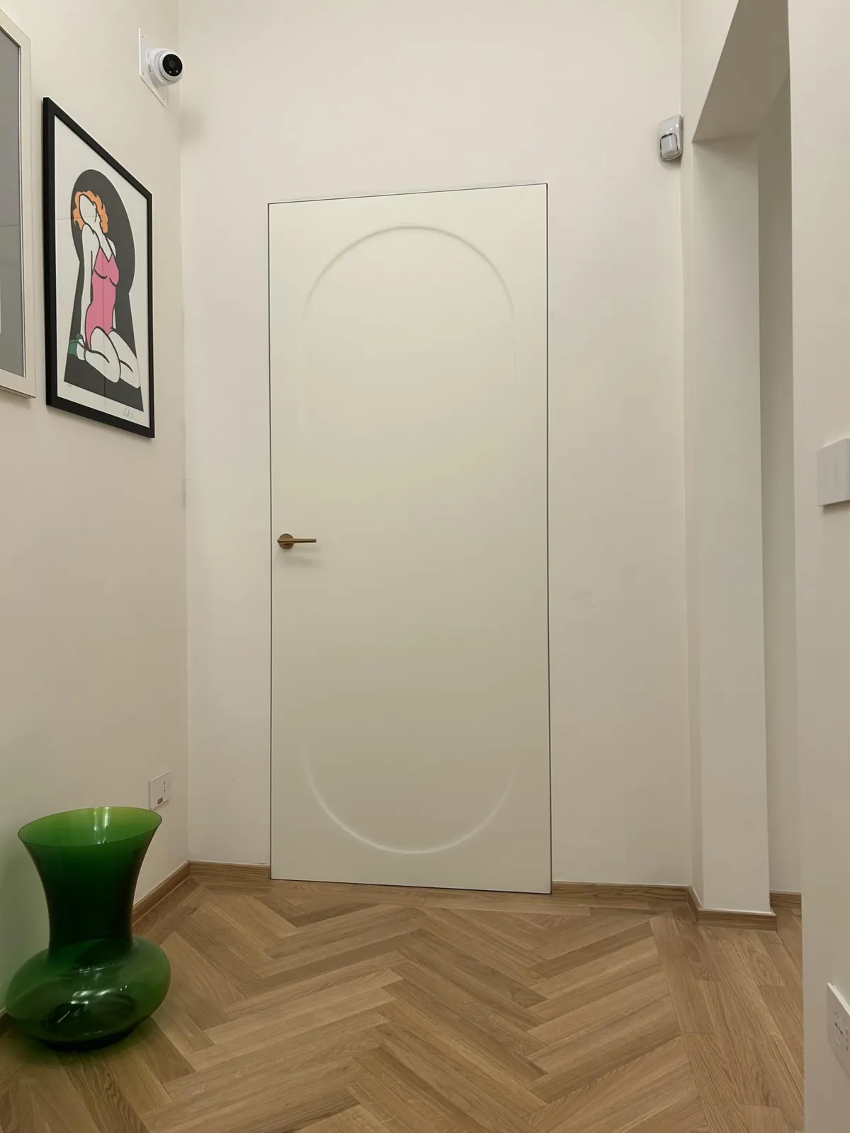 Porta interna bianca moderna con maniglia oro e decorazione ovale in rilievo.